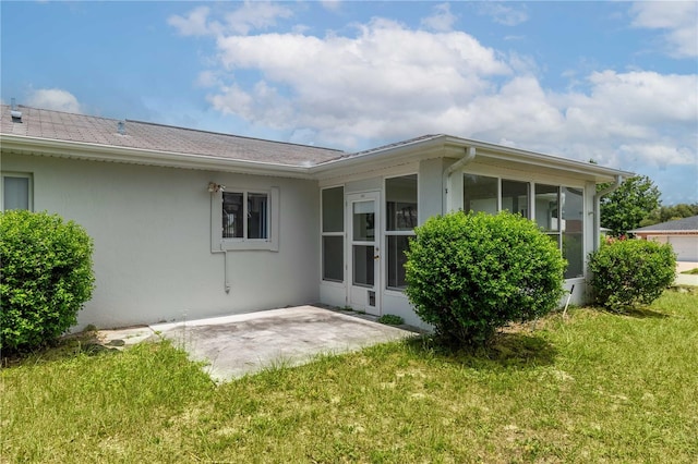 back of house with a yard, a patio, and a sunroom