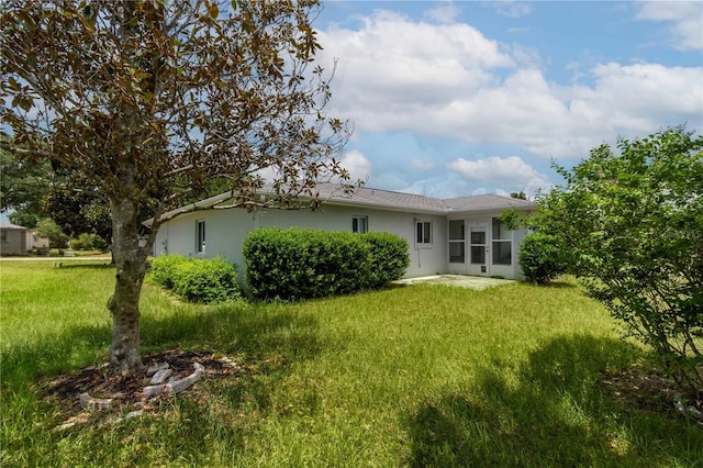 rear view of property featuring a lawn