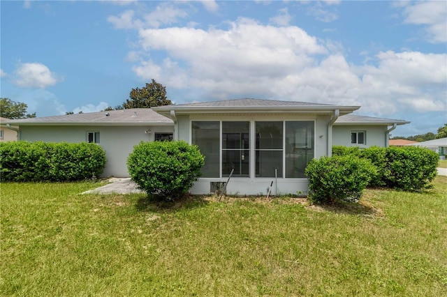 back of property featuring a yard and a sunroom