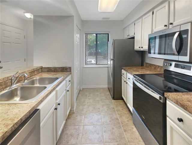 kitchen with white cabinetry, sink, light tile patterned floors, and appliances with stainless steel finishes