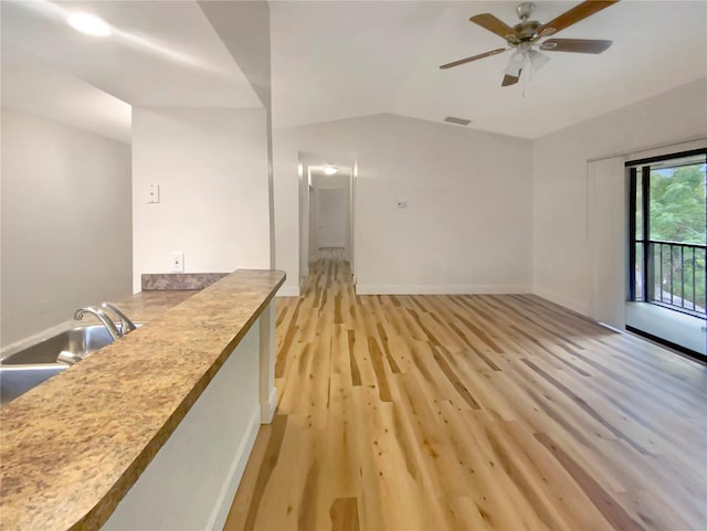 unfurnished living room with light hardwood / wood-style flooring, ceiling fan, lofted ceiling, and sink