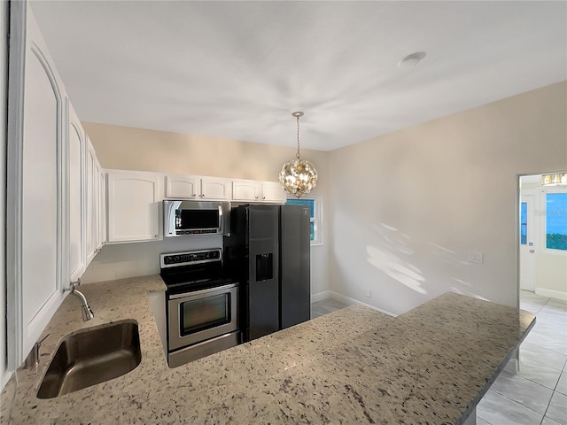 kitchen with white cabinets, sink, hanging light fixtures, light stone counters, and stainless steel appliances