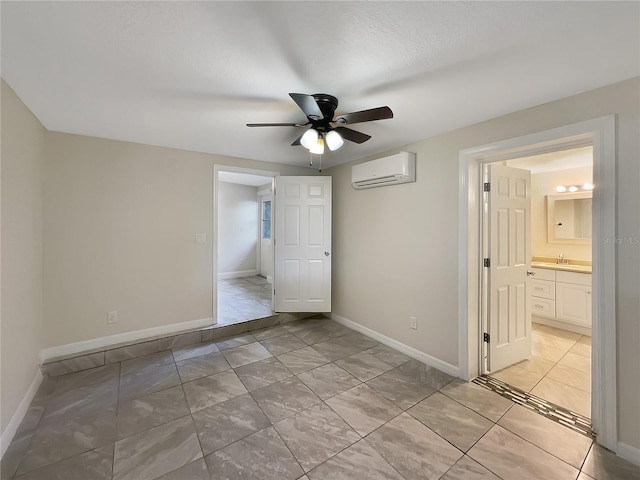 unfurnished room with a textured ceiling, a wall unit AC, ceiling fan, and sink