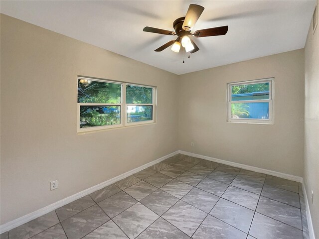 empty room with vaulted ceiling, ceiling fan, and a healthy amount of sunlight