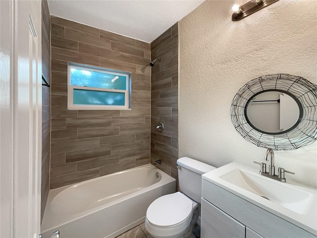 full bathroom with vanity, tiled shower / bath combo, and toilet