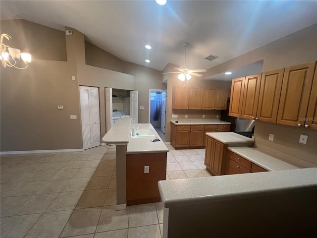 kitchen with light tile patterned flooring, ceiling fan with notable chandelier, lofted ceiling, sink, and a center island