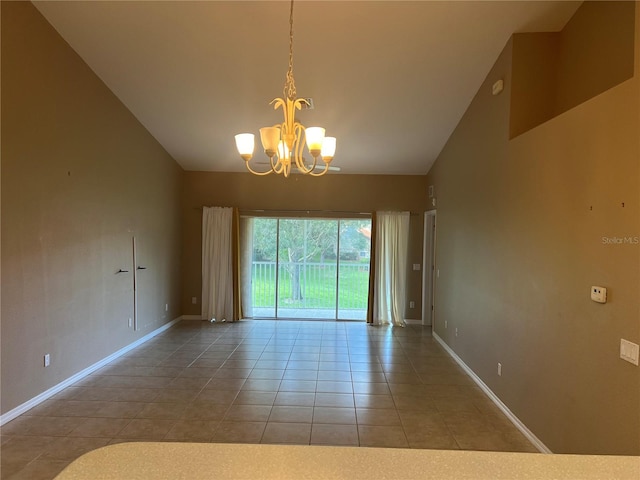 tiled empty room with an inviting chandelier and high vaulted ceiling