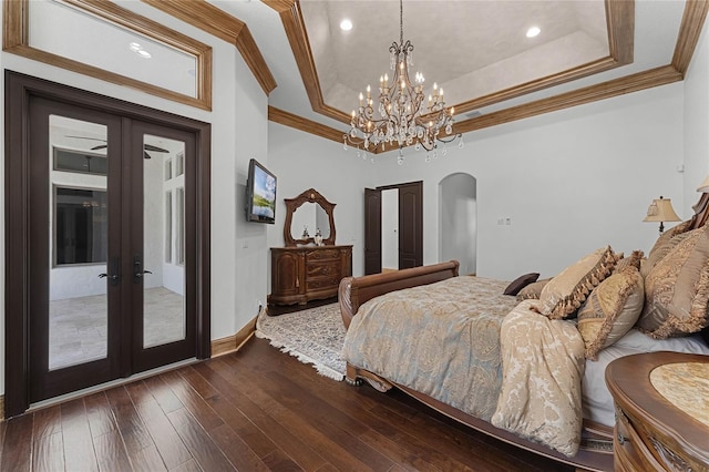 bedroom with french doors, dark wood-type flooring, ornamental molding, a tray ceiling, and access to exterior