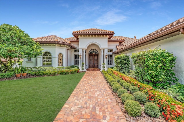 mediterranean / spanish house featuring a front lawn