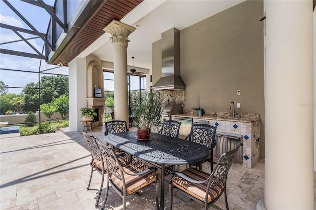 view of patio featuring sink, grilling area, an outdoor fireplace, a lanai, and ceiling fan