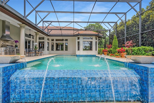 view of pool featuring pool water feature, ceiling fan, a grill, exterior kitchen, and a patio