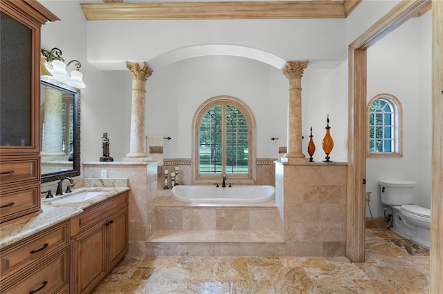 bathroom featuring toilet, ornate columns, ornamental molding, vanity, and tiled bath