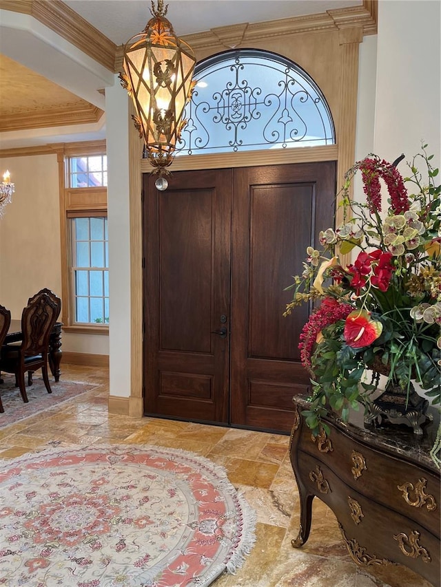 entrance foyer featuring an inviting chandelier and ornamental molding