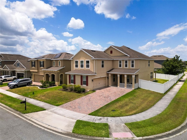 view of front of home featuring covered porch, a garage, and a front lawn