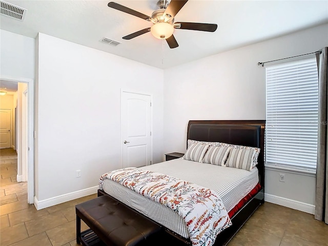 tiled bedroom featuring ceiling fan