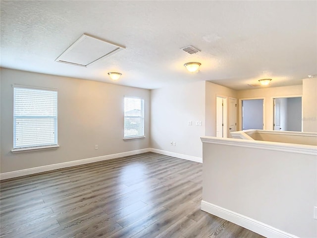 unfurnished room featuring hardwood / wood-style flooring and a textured ceiling