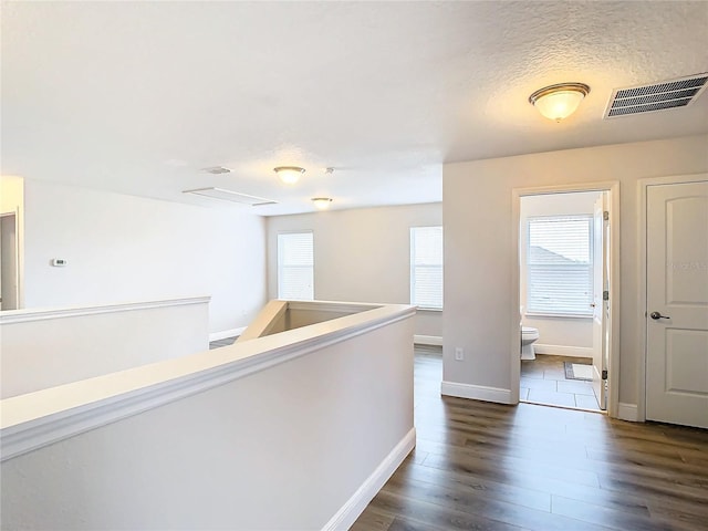 hallway featuring dark hardwood / wood-style floors and a textured ceiling