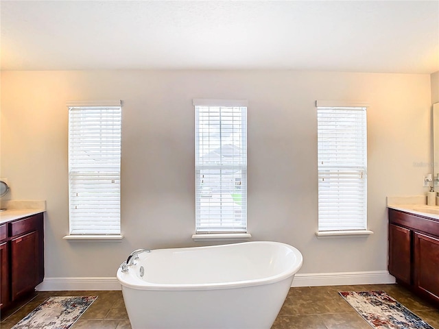 bathroom featuring tile patterned flooring, vanity, and a bathing tub