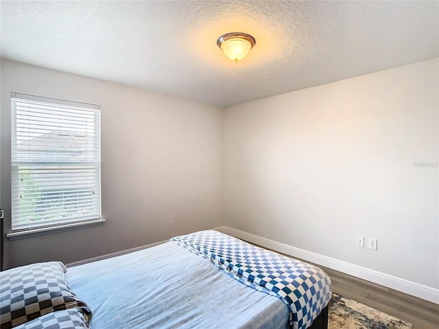 bedroom with wood-type flooring and a textured ceiling