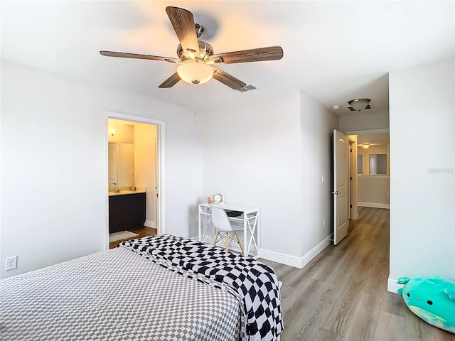 bedroom featuring ceiling fan, ensuite bathroom, and light hardwood / wood-style flooring