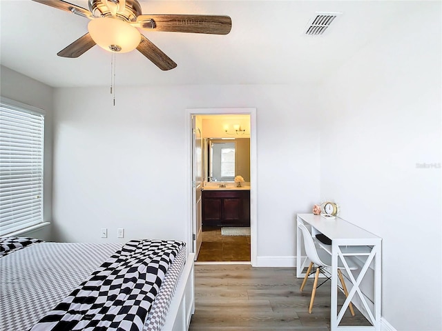 bedroom with ceiling fan, ensuite bathroom, and wood-type flooring