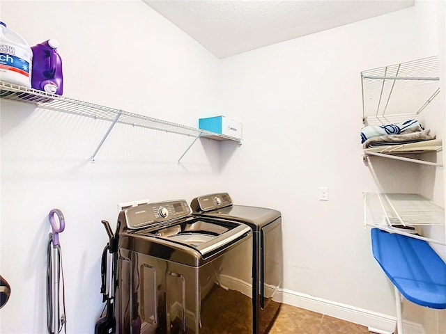 clothes washing area with light tile patterned floors and independent washer and dryer