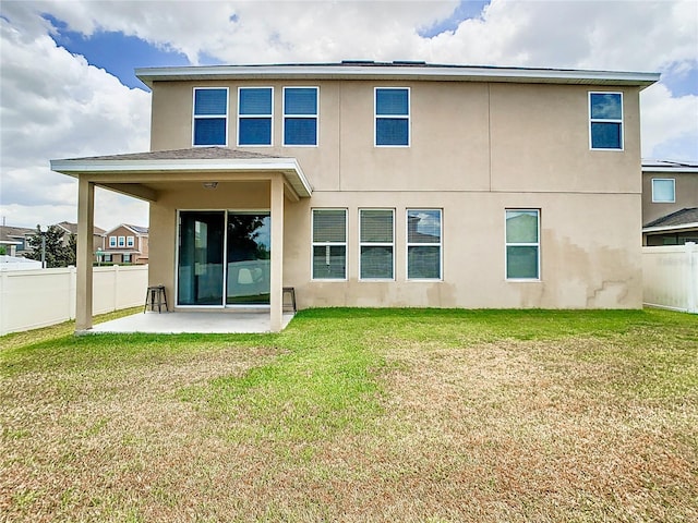 back of house with a yard and a patio