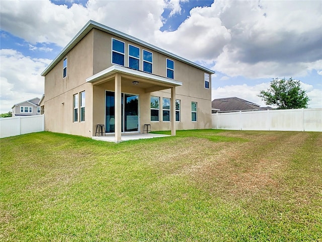 rear view of house with a patio area and a yard