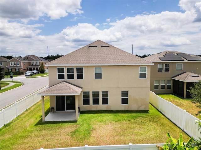 rear view of house with a lawn and a patio