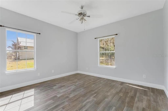 empty room featuring a healthy amount of sunlight, wood-type flooring, and ceiling fan