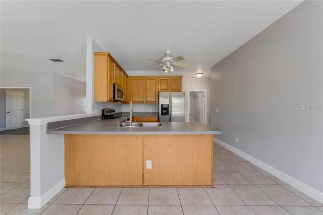 kitchen featuring ceiling fan, stainless steel appliances, kitchen peninsula, and light tile flooring