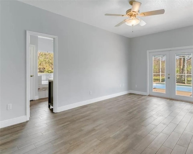 spare room with ceiling fan, french doors, and hardwood / wood-style flooring