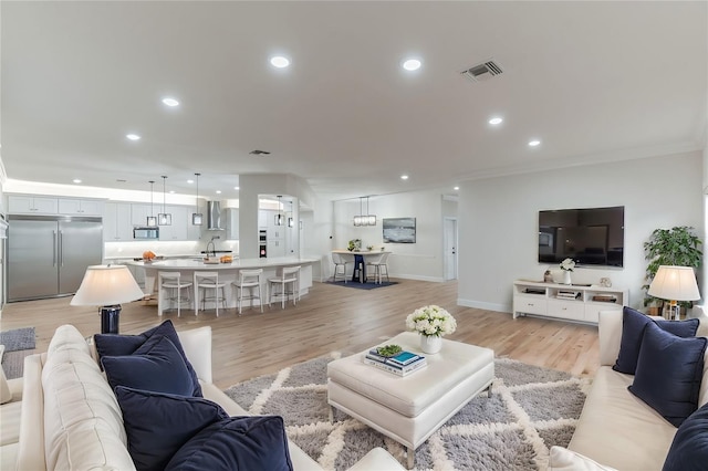 living room featuring light wood-type flooring and ornamental molding