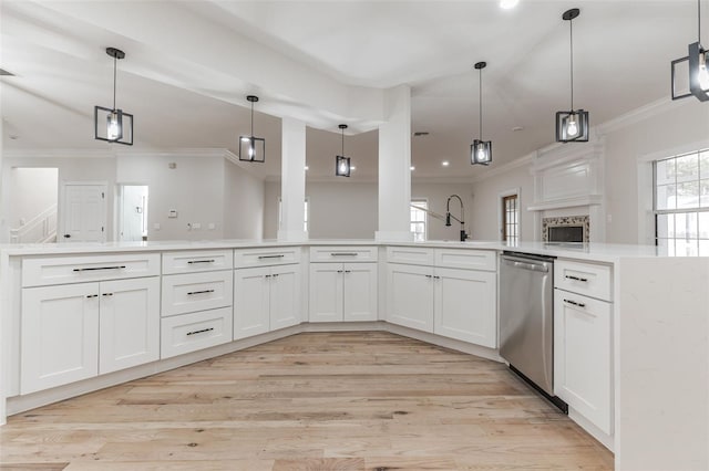 kitchen featuring light hardwood / wood-style flooring, white cabinets, stainless steel dishwasher, and decorative light fixtures