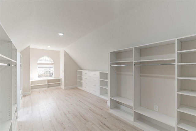 spacious closet featuring light hardwood / wood-style floors and vaulted ceiling