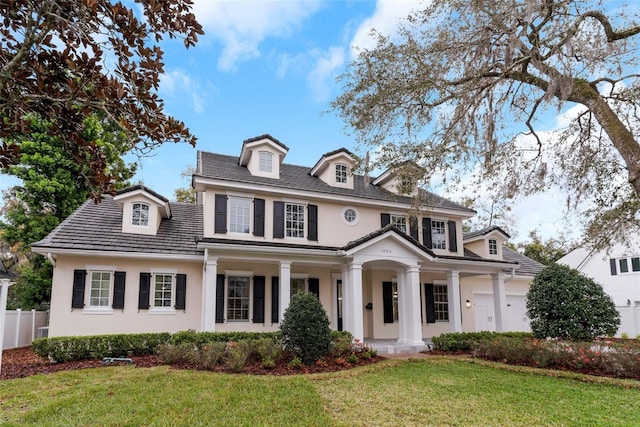 view of front of home with a front yard, an attached garage, and stucco siding