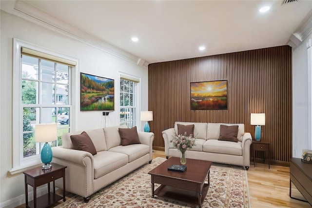 living area with visible vents, baseboards, light wood-style flooring, ornamental molding, and recessed lighting