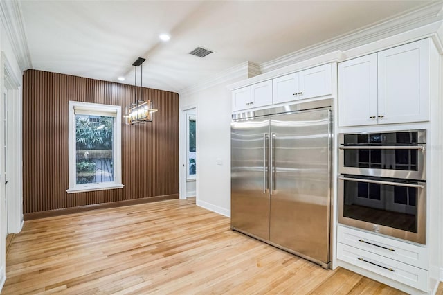 kitchen with visible vents, white cabinetry, light wood-style floors, hanging light fixtures, and appliances with stainless steel finishes