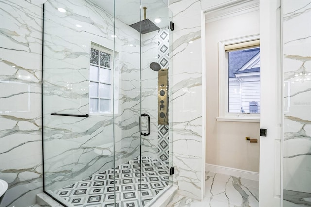 bathroom with marble finish floor, baseboards, and a marble finish shower