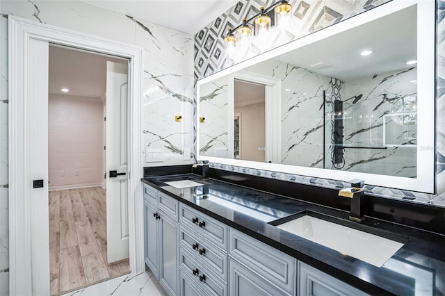 full bath with double vanity, marble finish floor, a sink, and recessed lighting