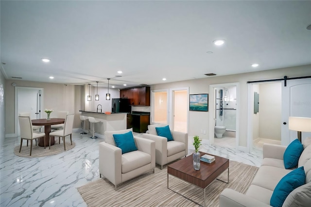 living area with marble finish floor, a barn door, and recessed lighting