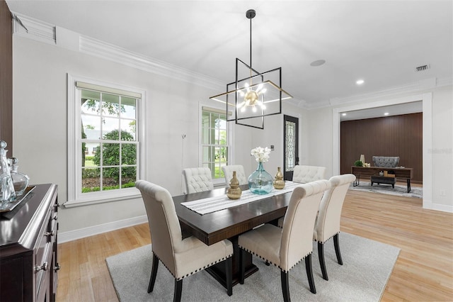 dining space featuring a chandelier, light wood-type flooring, baseboards, visible vents, and ornamental molding