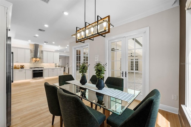 dining space featuring recessed lighting, crown molding, light wood-style floors, and french doors