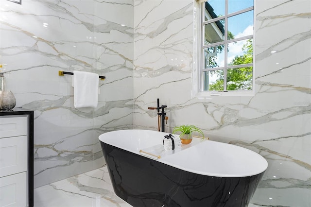 full bath featuring stone wall and a freestanding tub