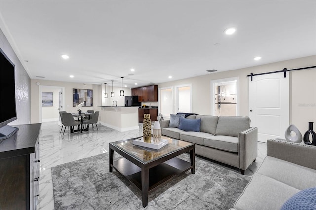 living area with visible vents, baseboards, marble finish floor, recessed lighting, and a barn door