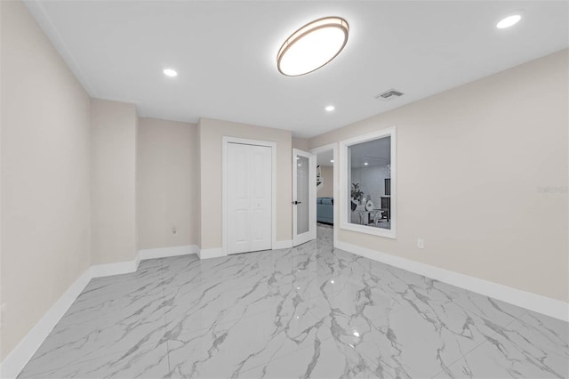 spare room featuring marble finish floor, baseboards, and visible vents