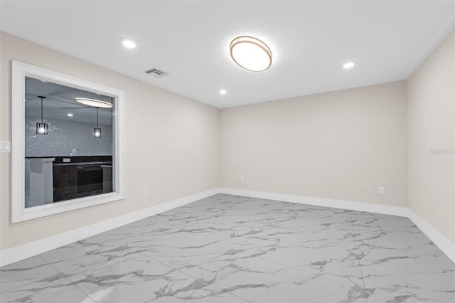 unfurnished room featuring marble finish floor, baseboards, and visible vents