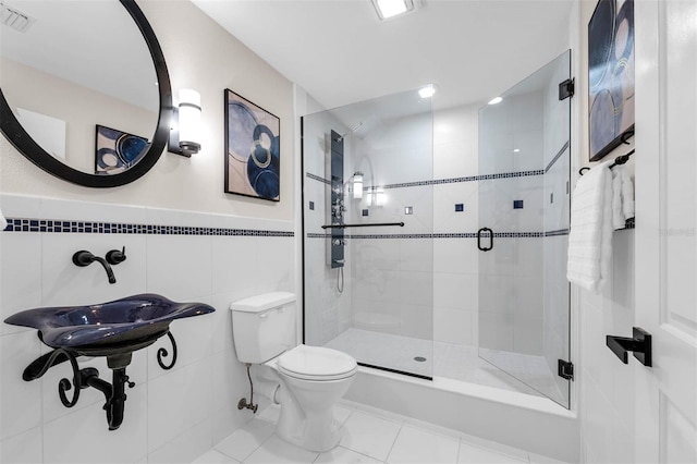 full bathroom featuring tile walls, visible vents, toilet, and a shower stall