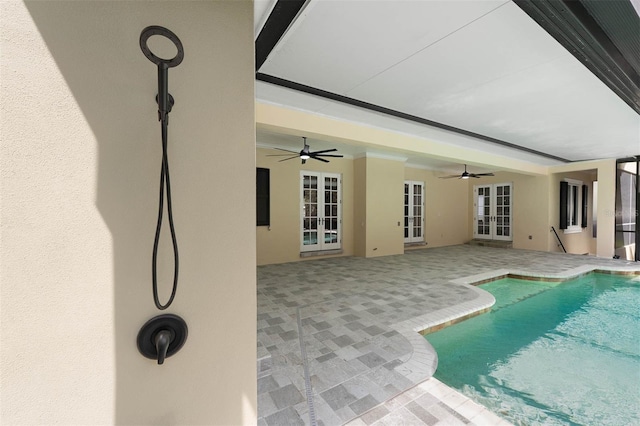 outdoor pool with french doors, a ceiling fan, and a patio area