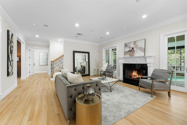 living area with recessed lighting, a high end fireplace, stairway, and light wood-type flooring
